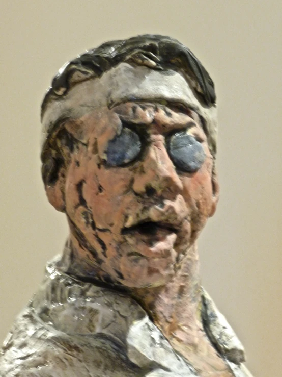 a statue made of clay with black eyes