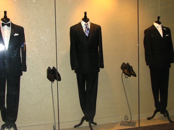 a display case has mannequins in suits and ties