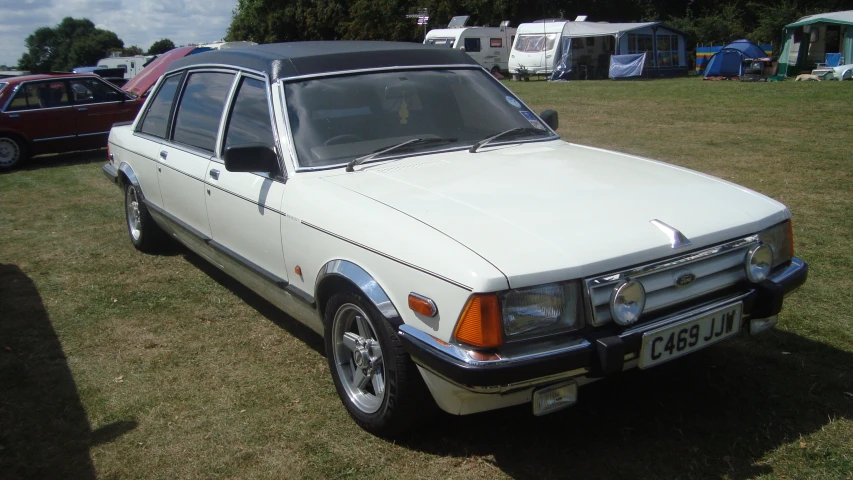 a white station wagon parked in a grassy field