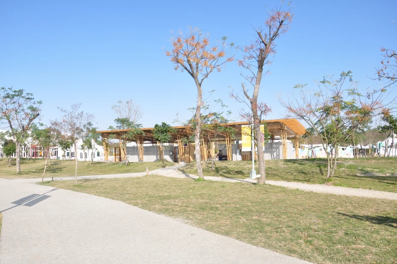 a building near the road with trees and a path next to it