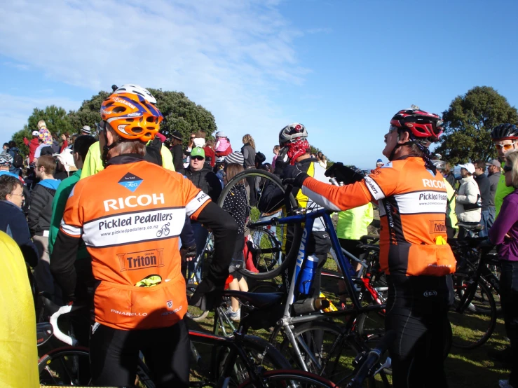 a group of bikers in the sun at the end of a race