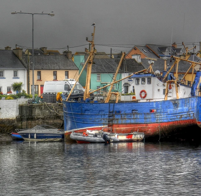 a very large blue and red boat docked by some houses