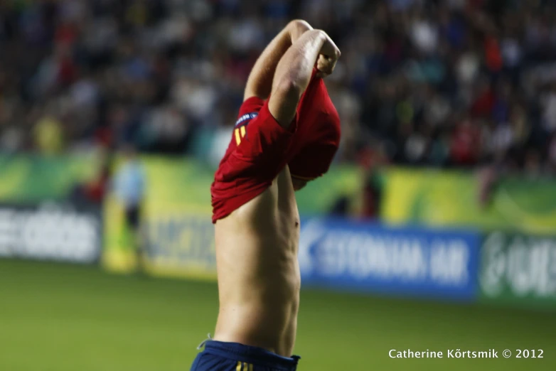 a man standing up in front of a crowd holding onto his shirt