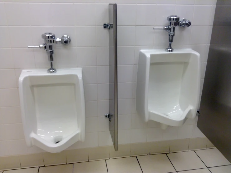 two urinals sitting next to each other in a bathroom