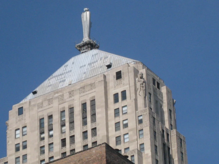 the building has a clock and a statue on top