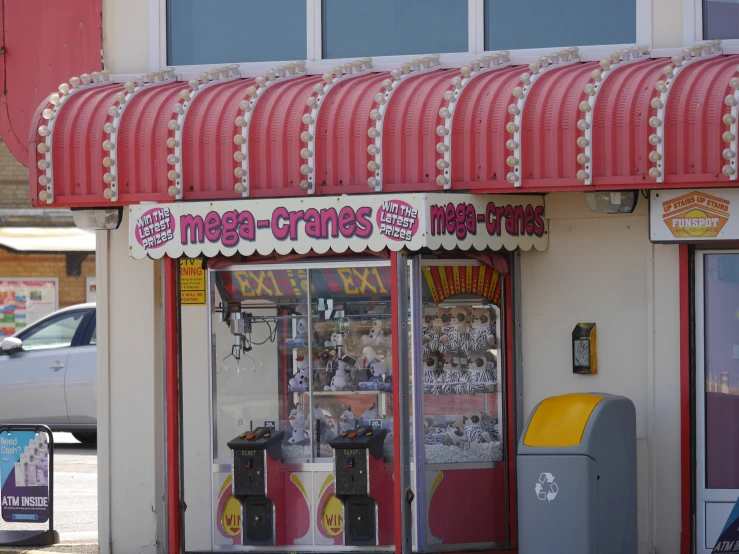 a restaurant with a red and white awning and a coke machine in front