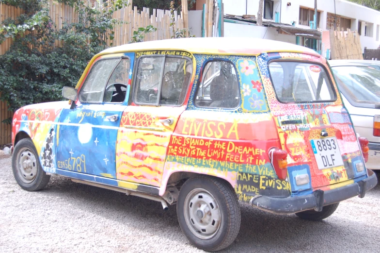 an old car with graffiti on it parked in a parking lot