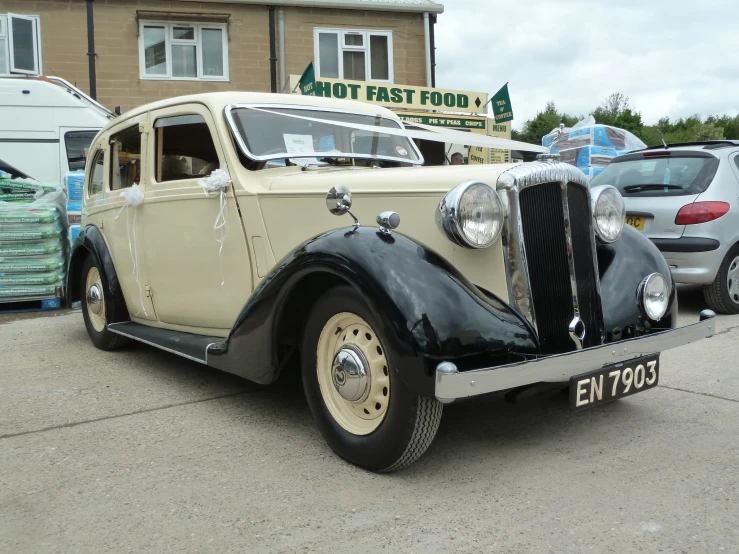 an old car sitting next to a lot of parked cars