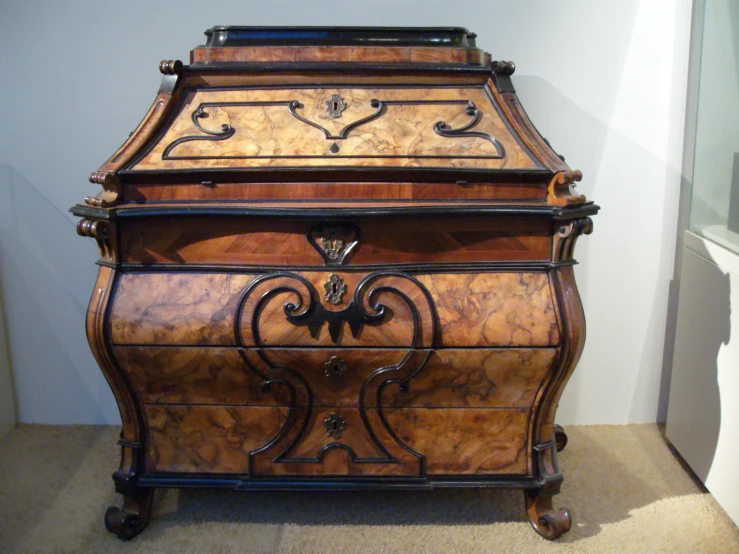 an old, elegant wooden bureau with decorative carvings