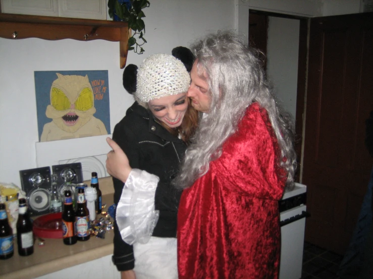 two women are hugging and laughing together in a kitchen