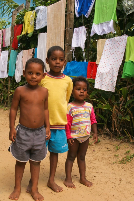 two little s stand in front of a clothesline