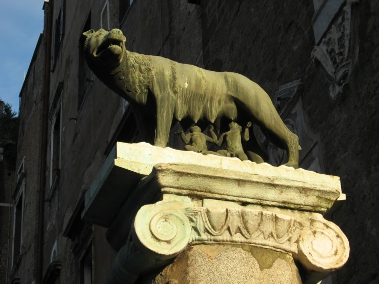 a statue of a dog on a ledge with an owl