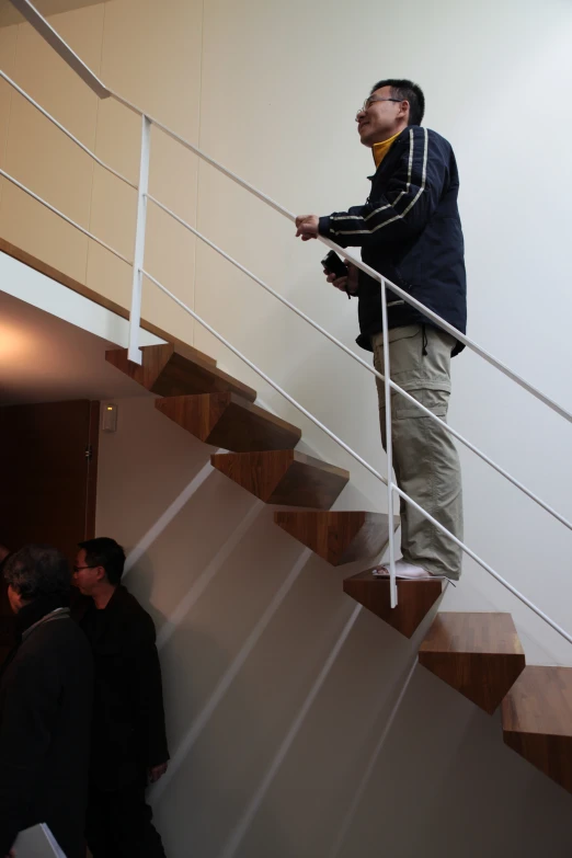 a person climbing a set of stairs holding on to the railing