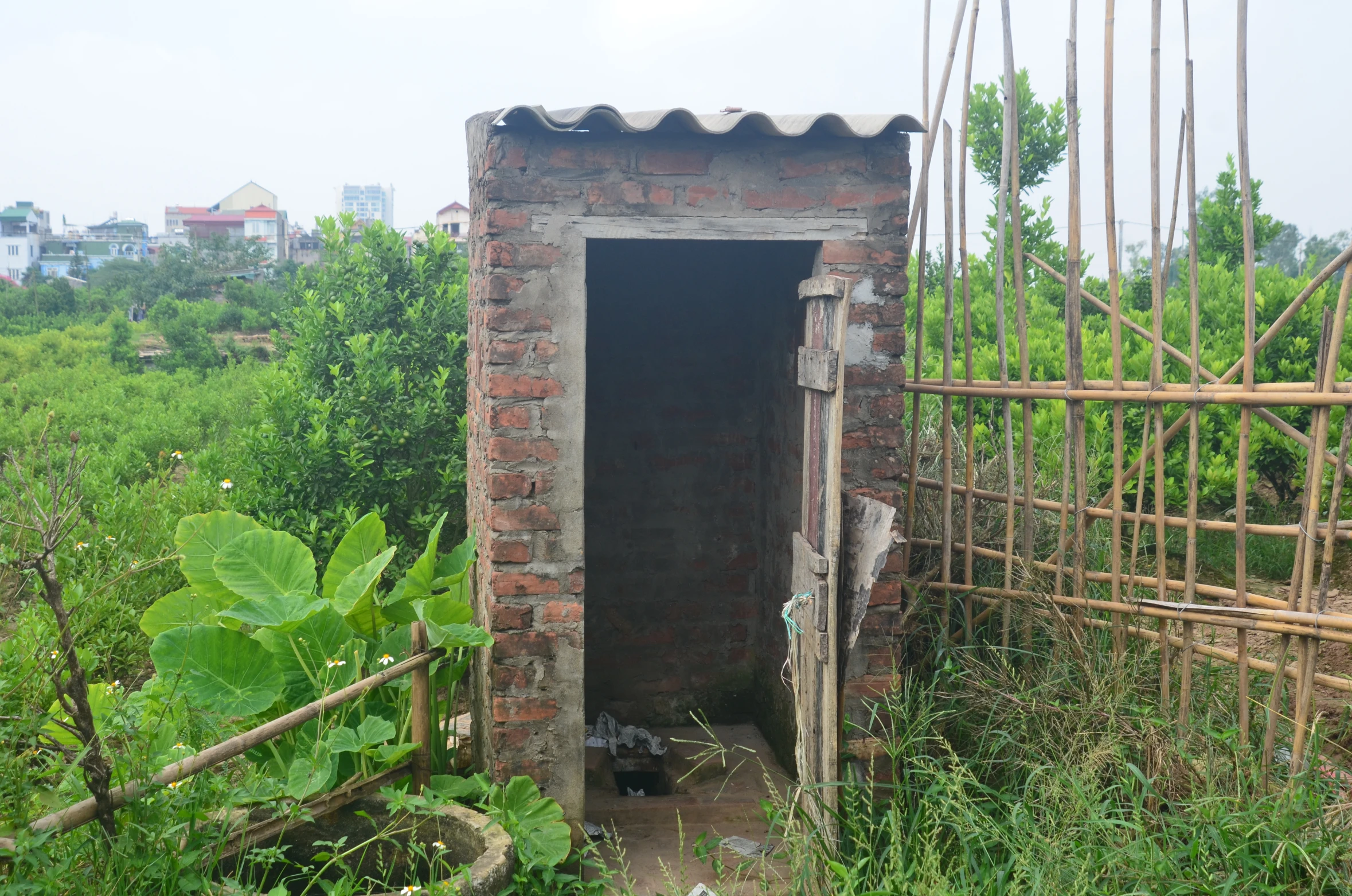 there is a brick structure with a door and a bucket in the center