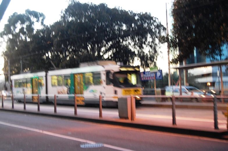 a long bus is stopped near a parking lot