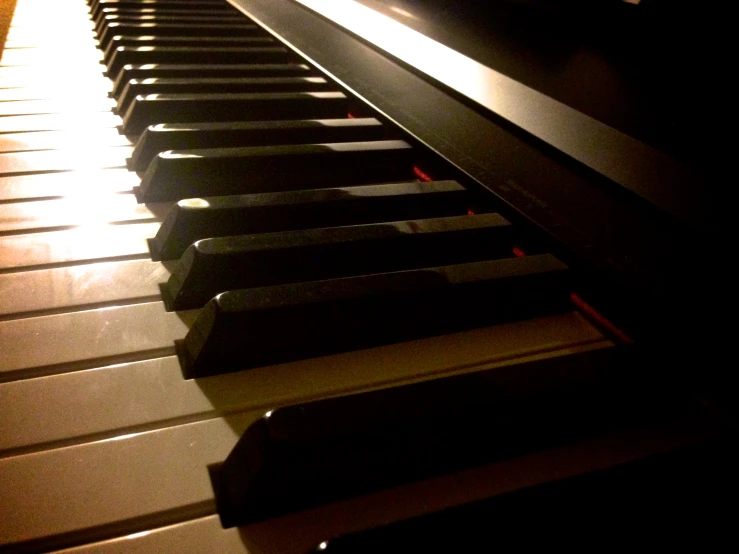 a closeup s of piano keys and light