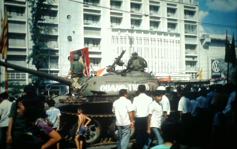 a couple of men standing next to a tank