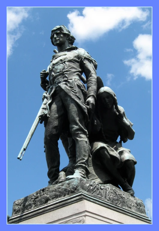 a statue of a soldier in front of some clouds