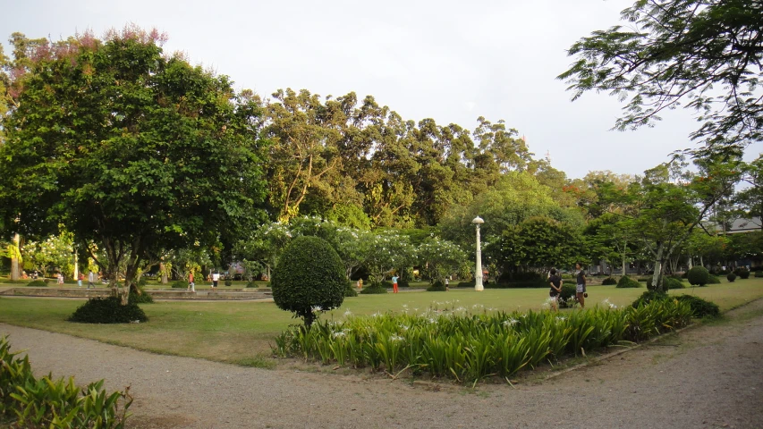 people are sitting on benches and walking around in a park