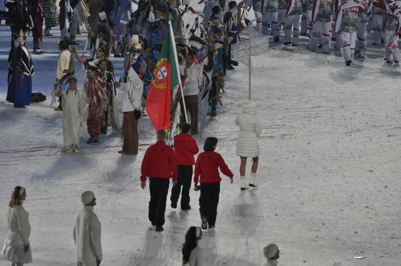 a group of people walking across a snow covered field