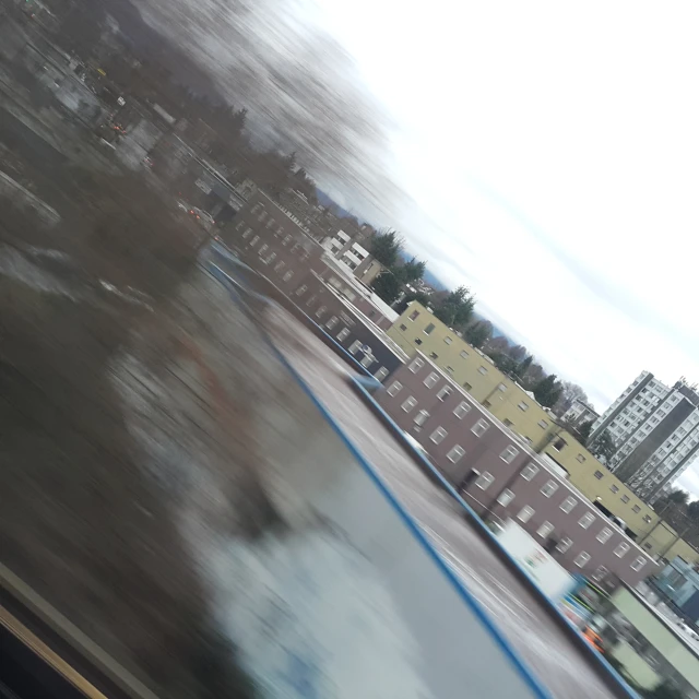 the blurry pograph shows buildings behind a fence