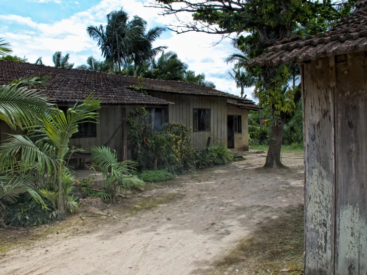 a house sitting on the side of a road next to trees