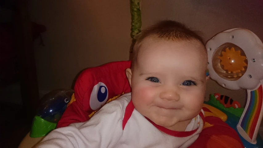 a smiling baby boy in a toy chair