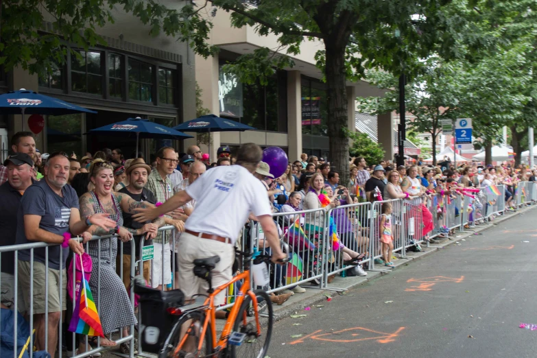 a man on a bike passing by a crowd