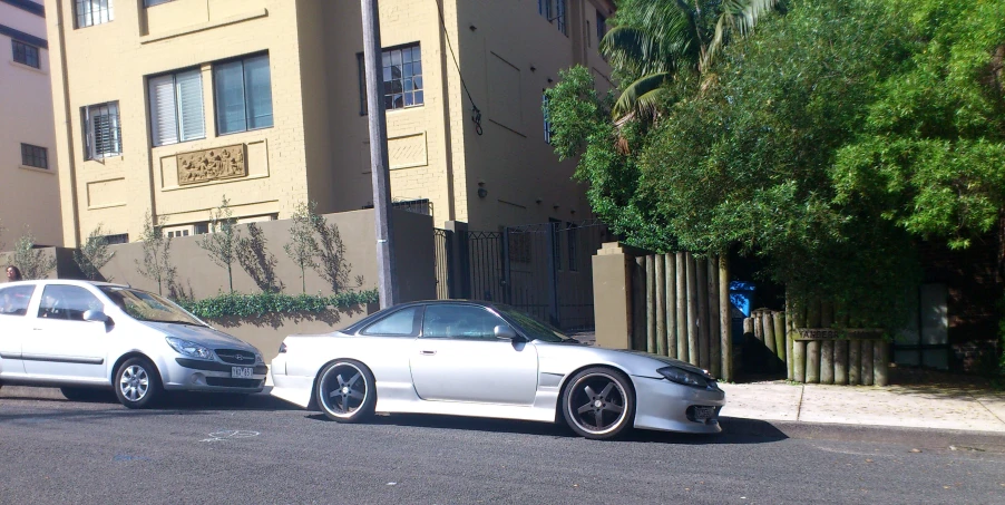 two white cars parked on a street side by side