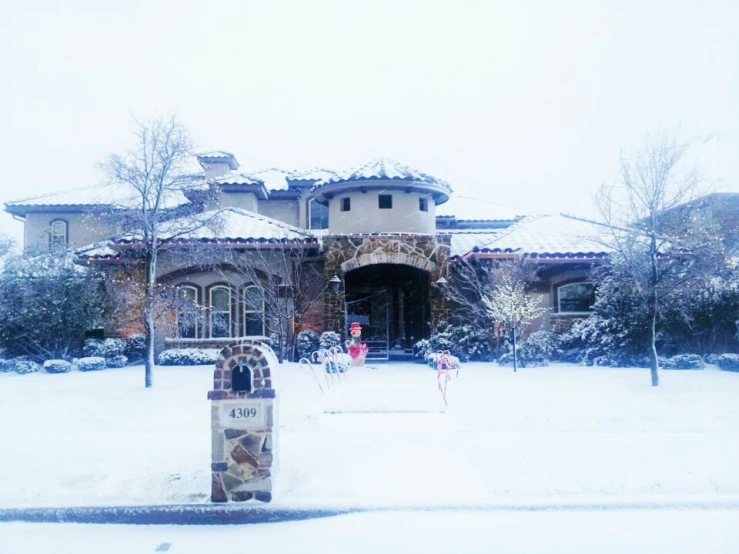 a snow - covered home with an outdoor mailbox in front of it