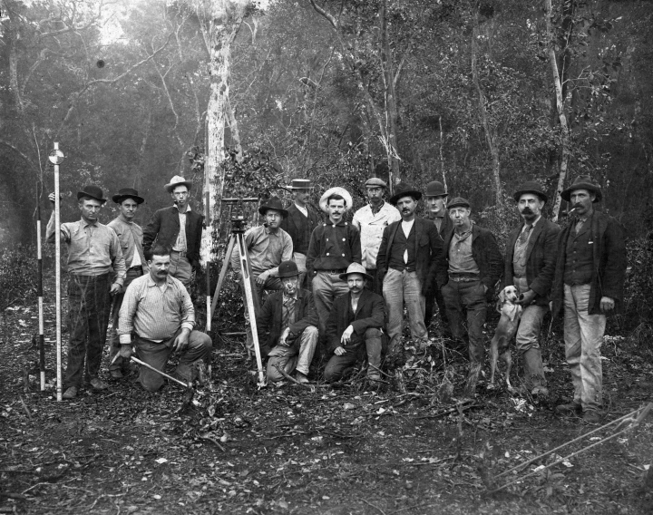 old time picture of a group of men wearing hats in the woods