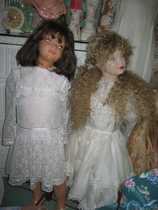 two dolls are dressed up as little white dresses