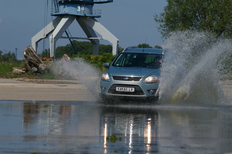 the car is driving through a flooded lot