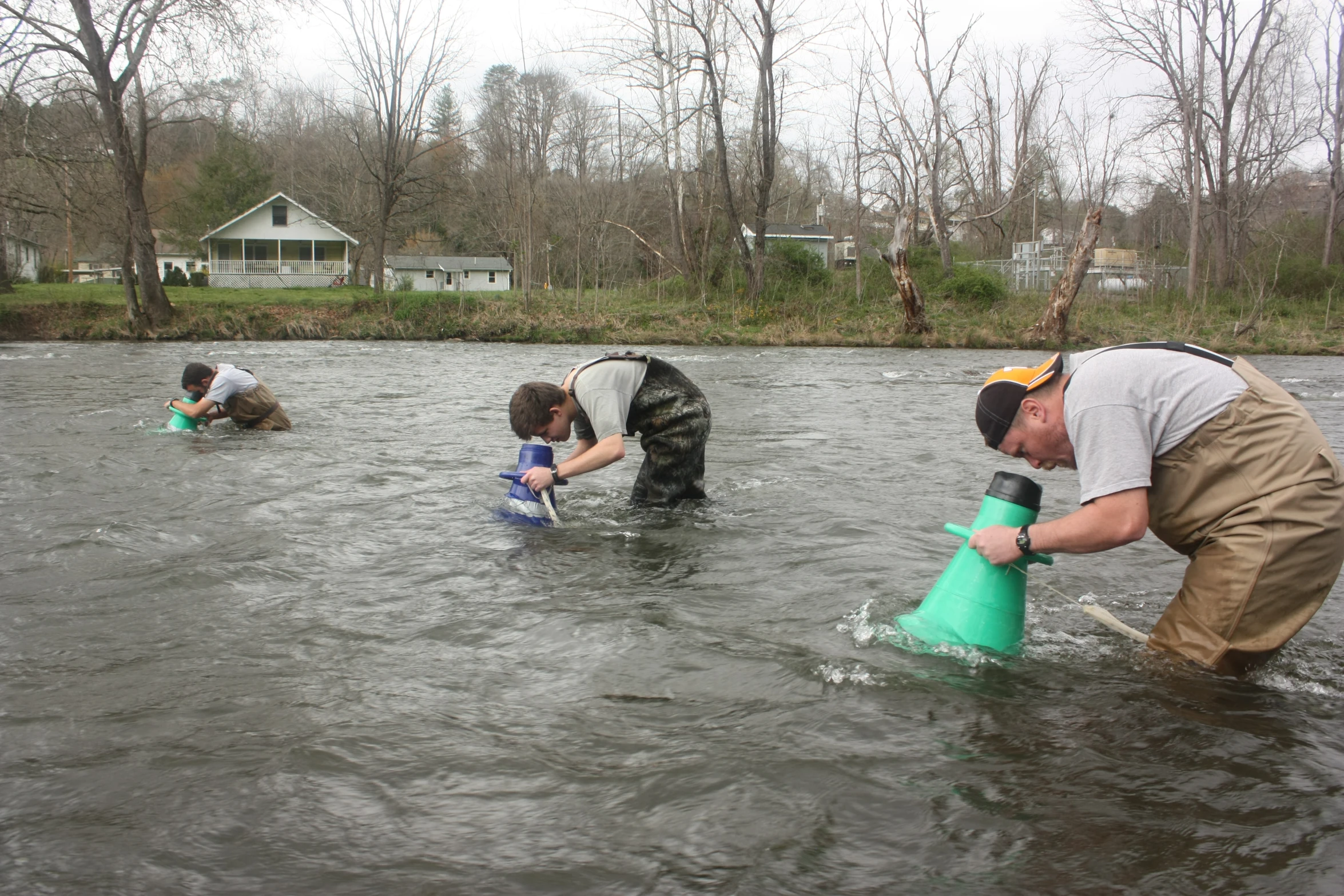 people are standing in water with a hose