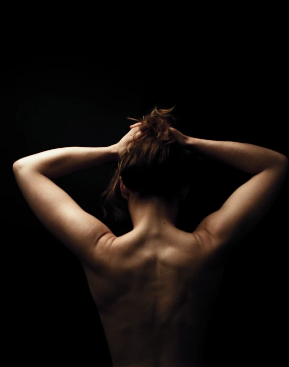 the back view of a woman with her hands on her hair