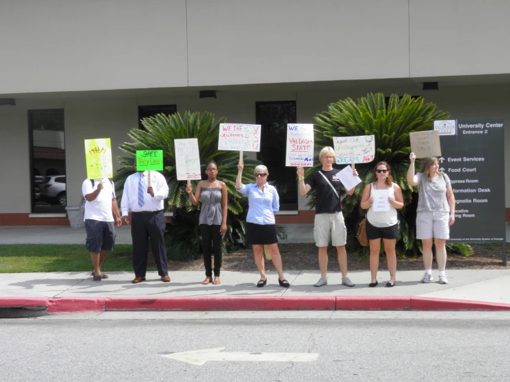 a group of people holding signs standing next to each other