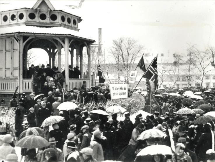 a large group of people hold umbrellas as they march