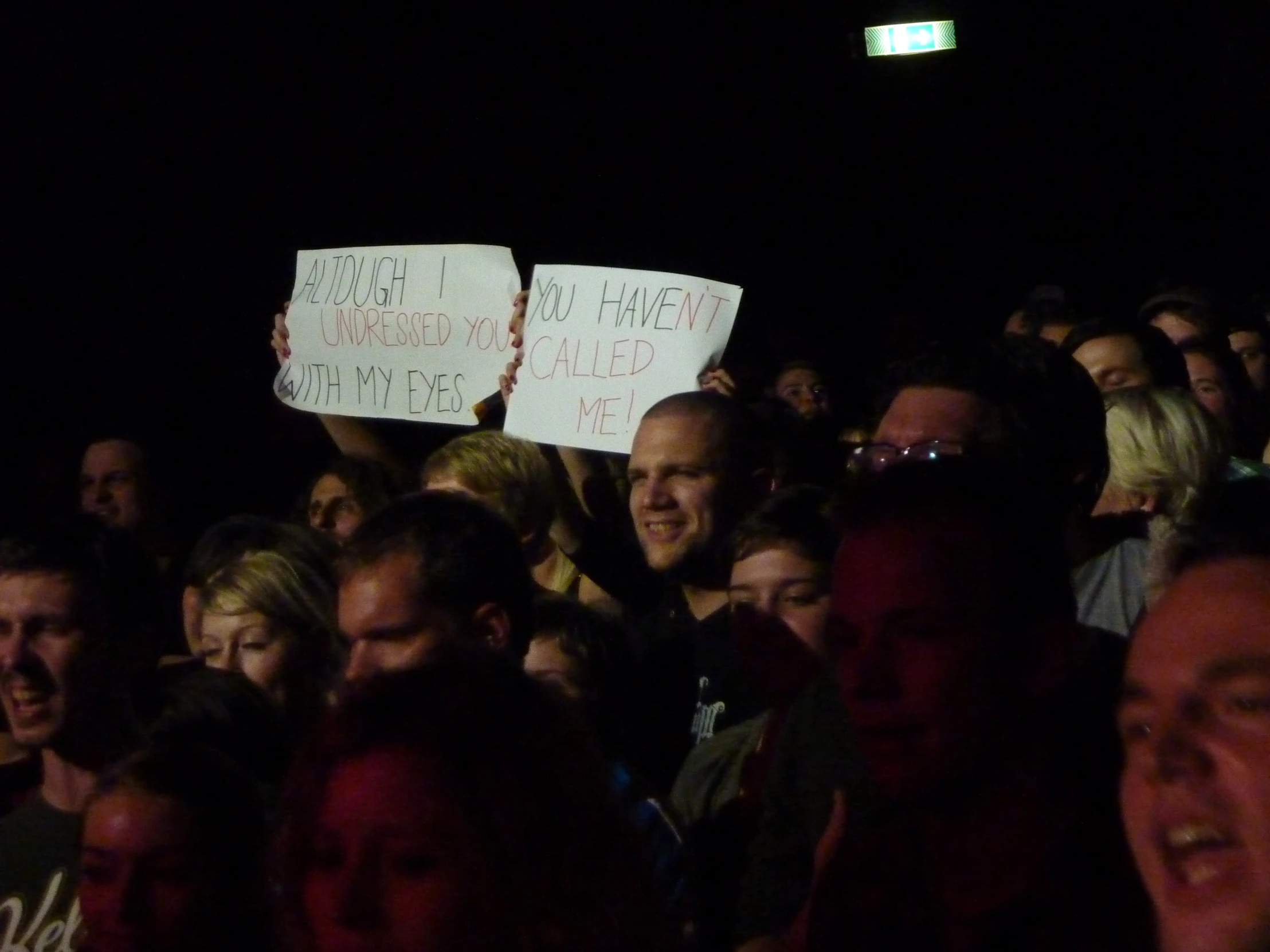 people at a concert with signs that read the words on them