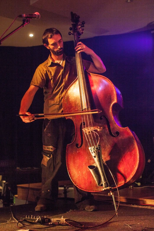 a man that is standing up playing a cello