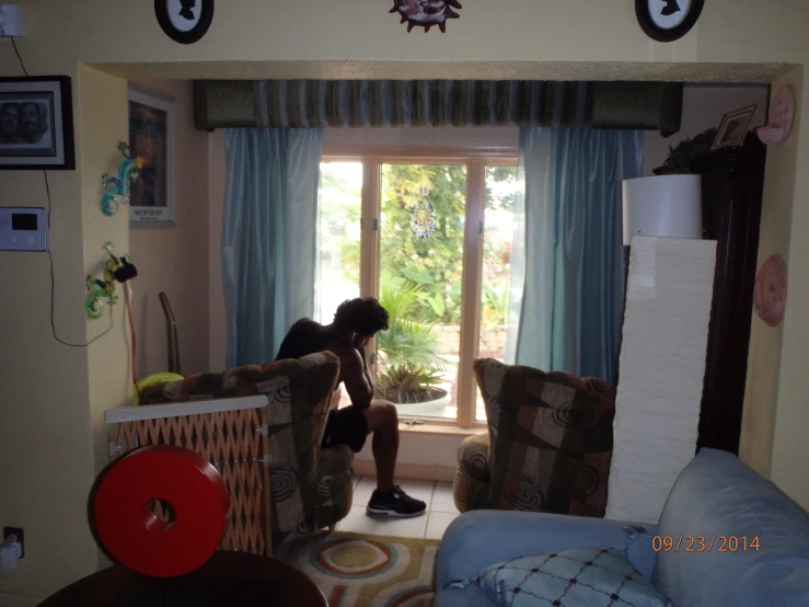 a young woman looking out the window while sitting on her couch