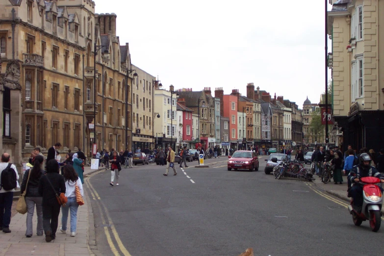 a street with several pedestrians and motor scooters