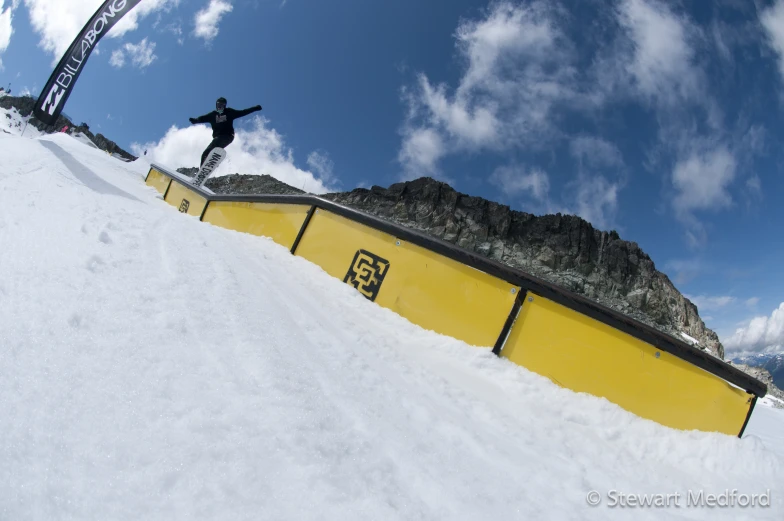 a snowboarder at the top of a half pipe