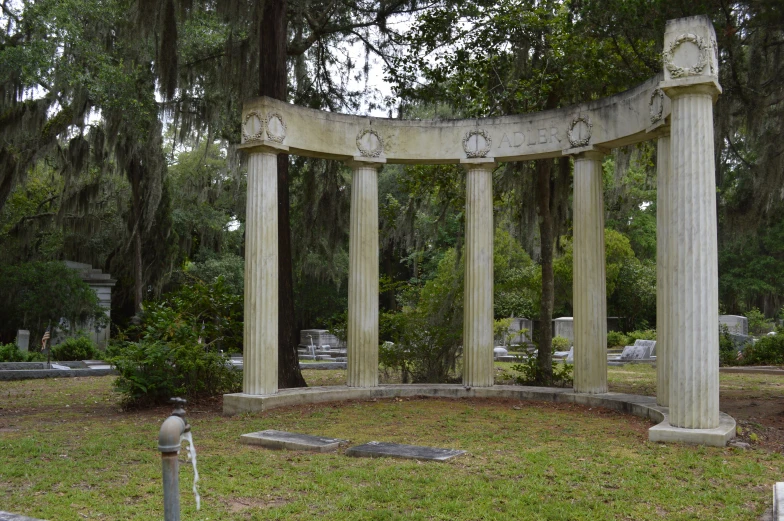 a large, ornately decorated stone monument on a lush green cemetery