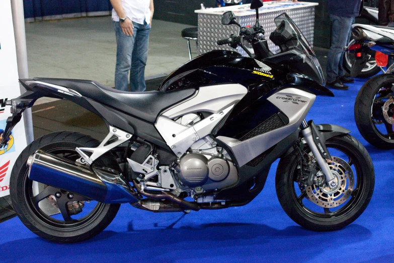 two motorcycle sitting on a blue carpeted floor