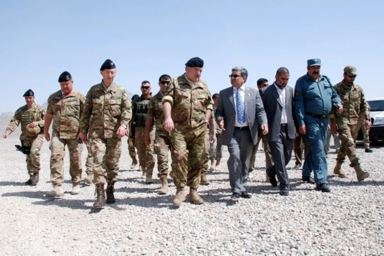 several military men walking along the beach