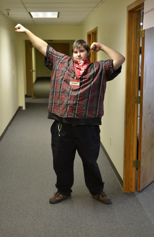 a man holding his arms out in an open hallway