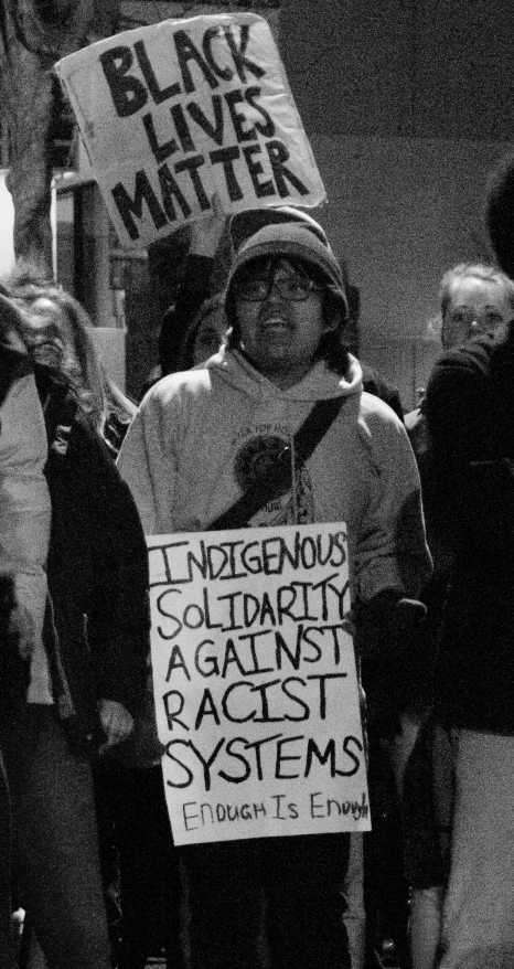 a woman holding a sign that says, black lives matter