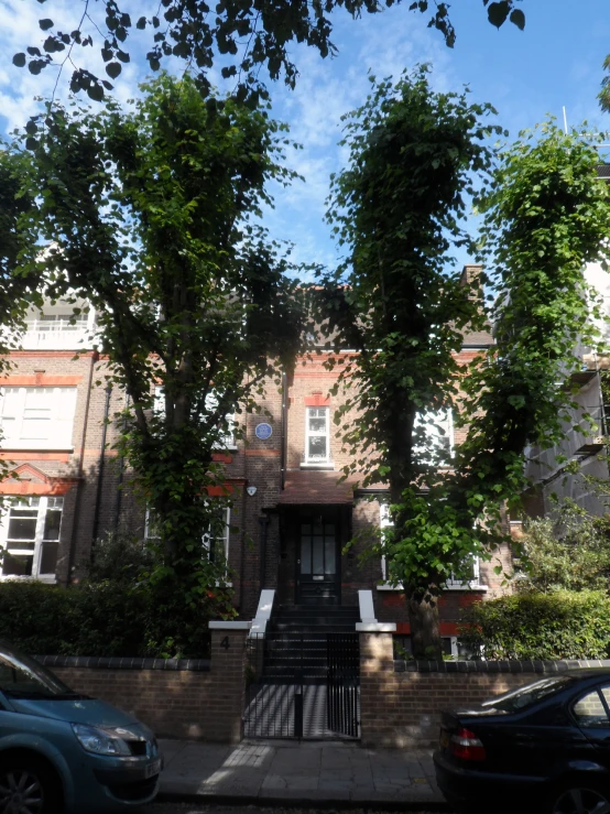 a city street with tall brick buildings and trees on either side of a door