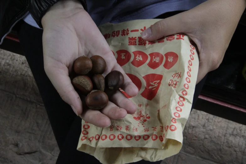 a person holding out two bags of nuts