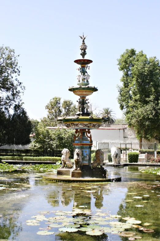 a fountain and pond with water lillies around it